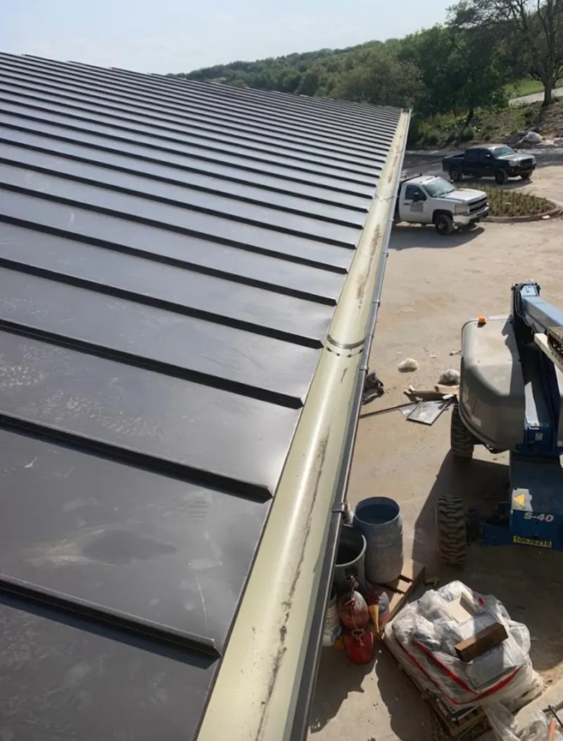 Standing seam panel and gutter detail on a metal roofing jobsite in Kronenwetter